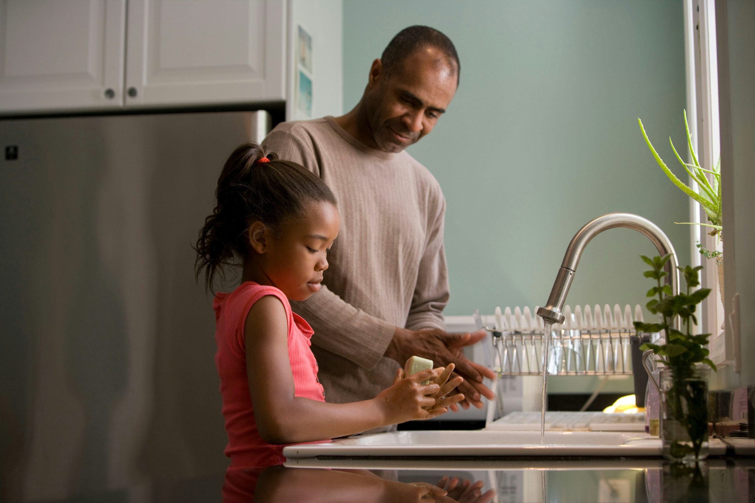 Anxiety in Older Adults Homepage - Older man with young girl at the sink washing dishes