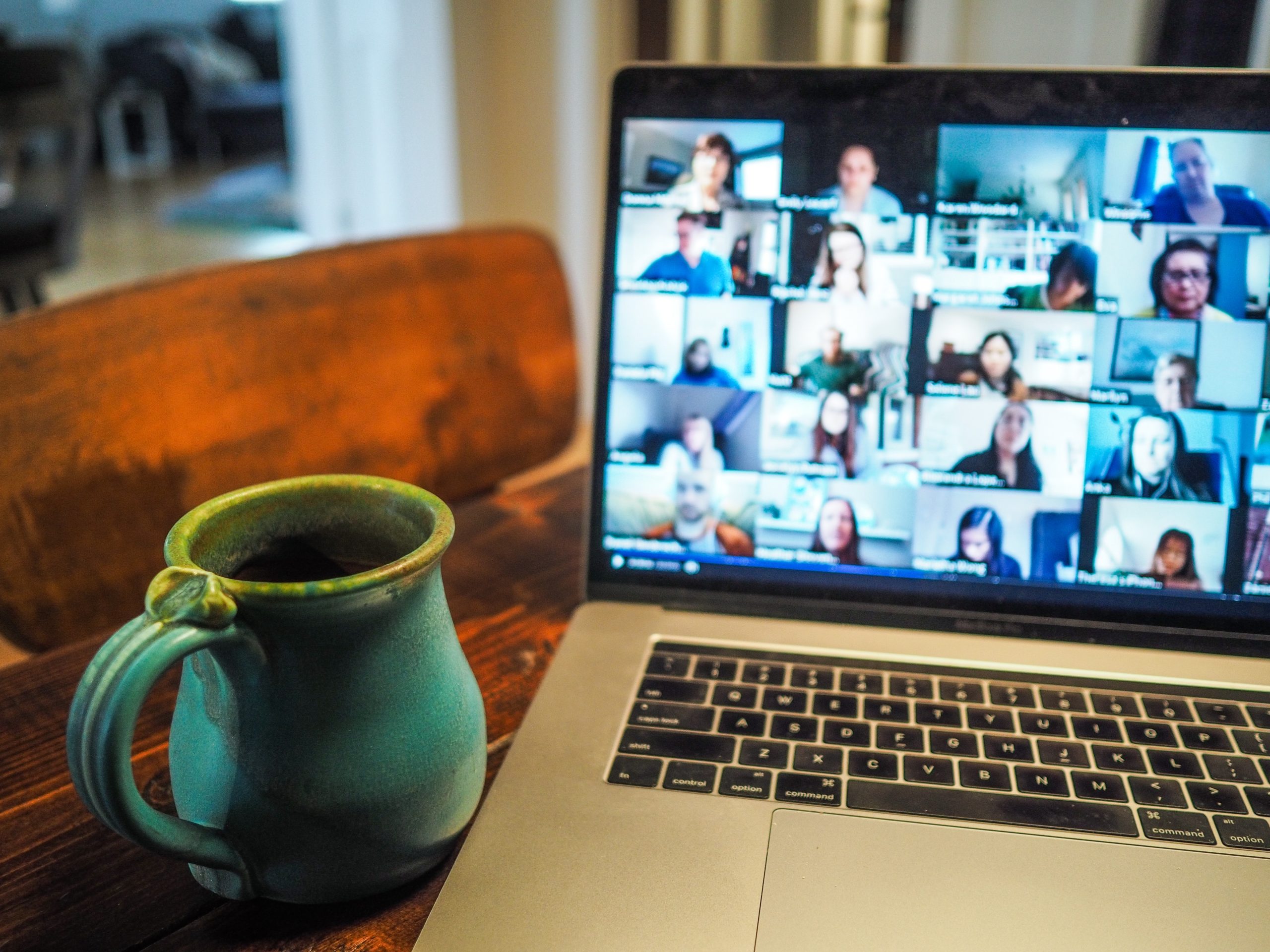 Image d'un appel virtuel sur un ordinateur portable avec une tasse à côté.