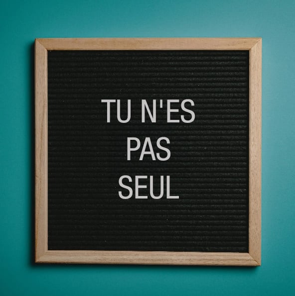 Un tableau d&#039;affichage sur lequel on peut lire &quot;Vous n&#039;êtes pas seul&quot;.