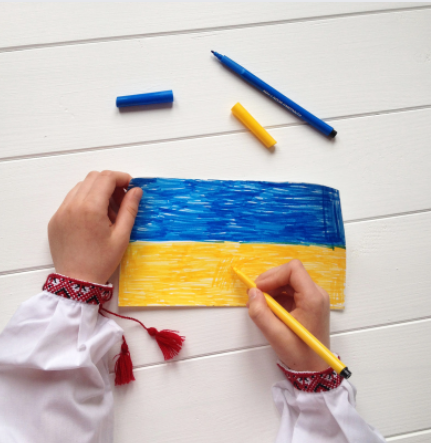 Child colouring Ukrainian flag